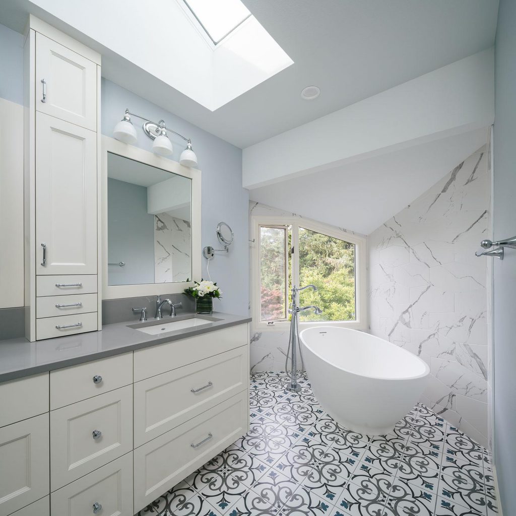 remodeled bathroom with white cabinets and a big white bathtub